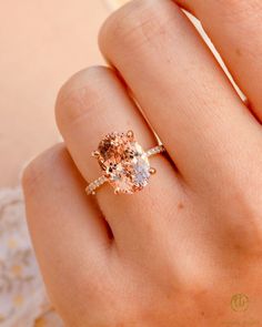 a woman's hand with a ring on it and an oval shaped morganite