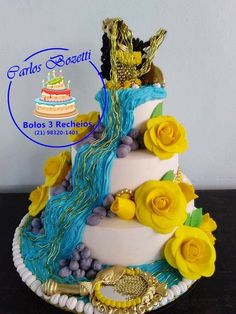 a three tiered cake with yellow flowers and blue icing on the bottom layer