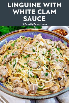 linguinne with white clam sauce in a blue bowl on a wooden table