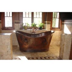 an old fashioned bathtub is in the middle of a tiled floored bathroom with two windows