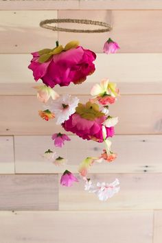 pink and white flowers hanging from a wooden ceiling