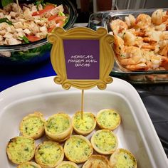 there are many different types of food in the trays on this table, including muffins and shrimp