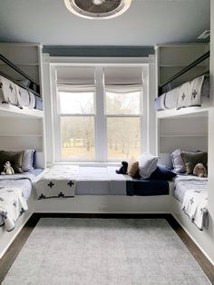 a bedroom with bunk beds and stuffed animals on the floor in front of a window