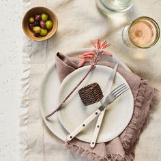 a white plate topped with a piece of cake next to a bowl of olives