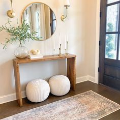 two large white balls sitting on top of a wooden floor next to a table with candles