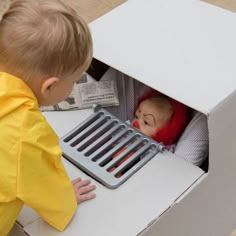 a little boy that is sitting in a box with some kind of thing on it