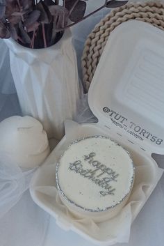 a birthday cake sitting on top of a table next to some flowers and other decorations