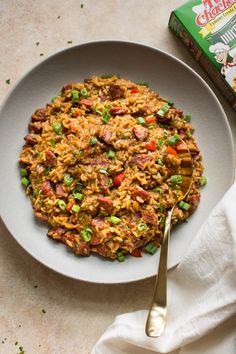 a white plate topped with rice and vegetables next to a box of cereal