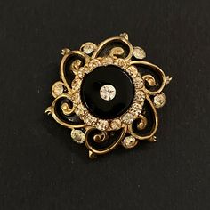 "Gold, black and clear glass is a classic combination, brought together to excellent effect in this small and lovely mourning brooch. The black of the onyx is echoed in the black enamel accentuating the gold. This design was copied by Coro in the mid century, but this brooch is the real thing, as indicated by the pin which extends 1/8\" beyond the clasp, where more modern pins do not. Circa 1900-1910, or perhaps a little later, which would make it Edwardian. The piece is extremely well made and solidly constructed. All parts are intact. Measures 1 3/8\" in diameter. In excellent condition." Sweet Notes, Antique Victorian, Black Enamel, Clear Crystal, Gold Black, Brooch Pin, Brooches, Clear Glass, Onyx