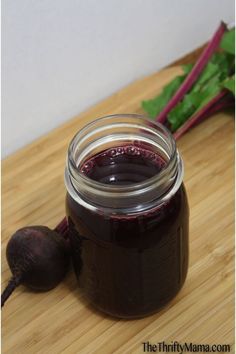 a jar of beet jam sitting on top of a wooden table next to radishes