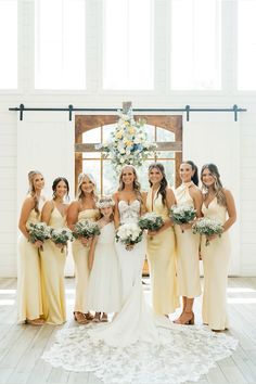 a group of women standing next to each other in front of a white and yellow wall