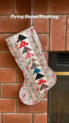 a christmas stocking hanging from the side of a brick wall next to a fireplace