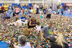 many people are sitting on the floor covered in legos