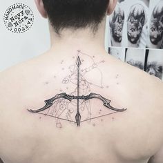 the back of a man's neck with an arrow and stars tattoo on it