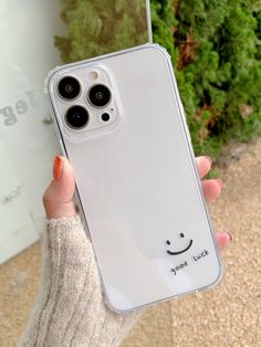 a person holding up a clear case with a smiley face on it