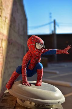 a toy spider man sitting on top of a white object