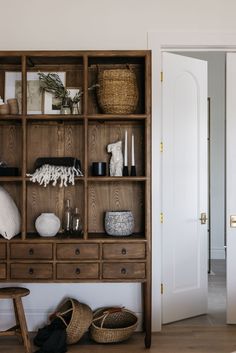 a wooden shelf with baskets and other items on it