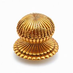 a golden shell shaped object on a white background