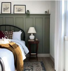 a bed sitting next to a lamp on top of a wooden table