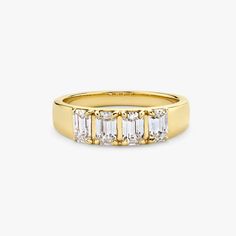 a yellow gold ring with three baguettes on the side and two rows of diamonds