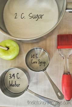 measuring spoons, an apple and sugar are on a table with ingredients for the recipe