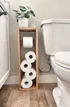 a bathroom with toilet paper stacked up on a shelf