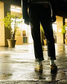 a person standing in the rain with yellow shoes