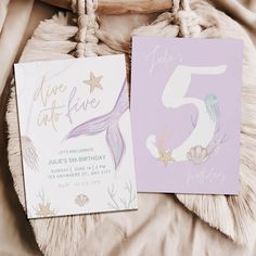 two birthday cards sitting on top of a bed next to a bag and pillow with the number five