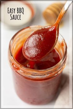 a spoon full of bbq sauce on top of a jar with the words easy bbq sauce above it