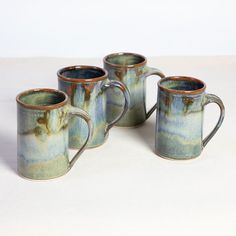 three coffee mugs sitting next to each other on a table