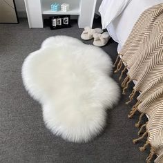 a white sheepskin rug on the floor next to a bed