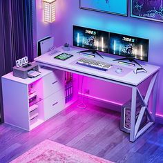 a white desk topped with two monitors next to a pink rug and purple wallpaper