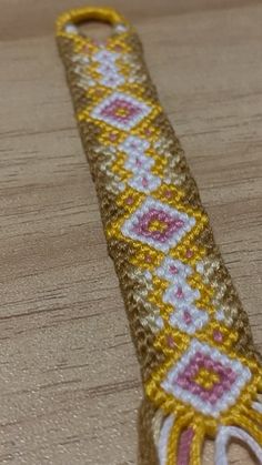 a close up of a piece of cloth on a wooden surface with a tassel