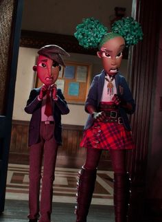 two dolls are standing next to each other in front of a door with green hair