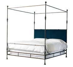 an iron bed frame with blue velvet upholstered headboard and foot board is shown