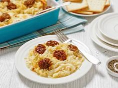 a white plate topped with macaroni and cheese next to a casserole dish