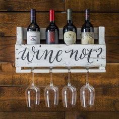 wine glasses and bottles are hanging on a wooden sign that says, wine not?