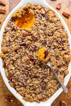 a serving dish filled with baked oatmeal and pecans on a wooden table