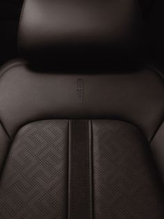 the back seats of a car with black leather upholstered and diamond stitching