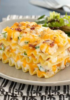 a close up of a plate of food with pasta and salad on the side,