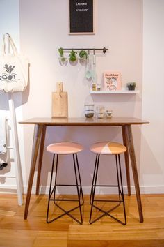 two stools sitting under a wooden table