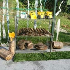 there is a rack with logs and other items on the ground next to a fence