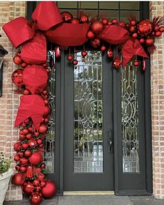 the front door is decorated with red ornaments and bows for holiday decorations on it's side