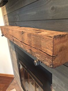 an old fireplace is being displayed in a room with wood planks on the wall