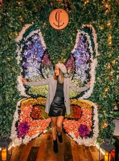 a woman standing in front of a butterfly decoration