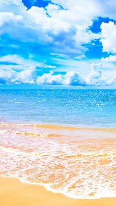 an ocean beach with waves crashing on the sand and clouds in the sky above it