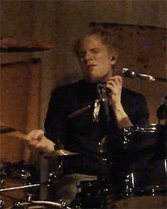 a man sitting in front of a drum set