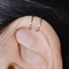 a woman's ear with two thin rings on it