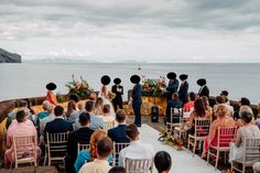 a couple getting married at the end of their wedding ceremony by the ocean on a cloudy day