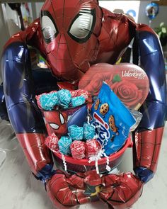 a spiderman balloon and some candy in a basket